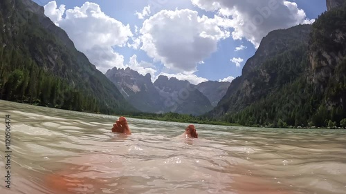 Tourist relaxing in the turquoise water of lago di landro in the dolomites, italy photo