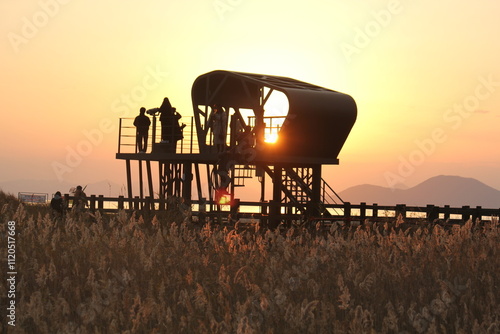 Image of people enjoying a beautiful sunset at Dadaepo Beach in Busan and a landscape image of sunset at sea
