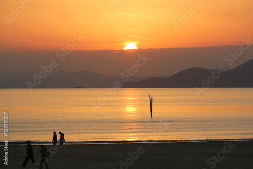 Image of people enjoying a beautiful sunset at Dadaepo Beach in Busan and a landscape image of sunset at sea
 photo