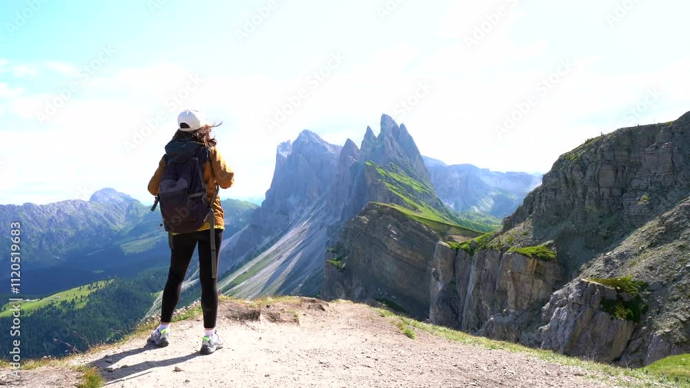 Female hiker admiring the majestic dolomites landscape in summer Female hiker admiring the majestic dolomites landscape in summer