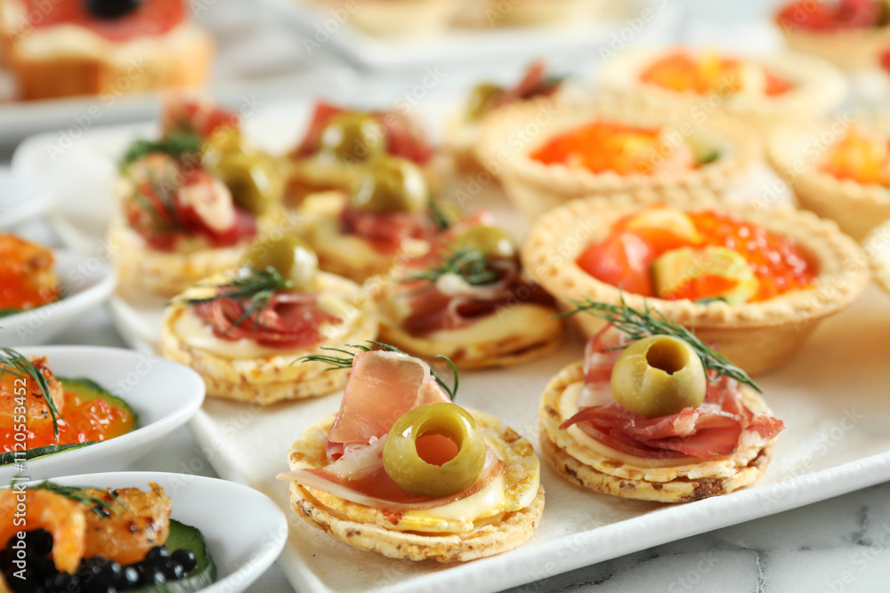Many different tasty canapes on white marble table, closeup Many different tasty canapes on white marble table, closeup
