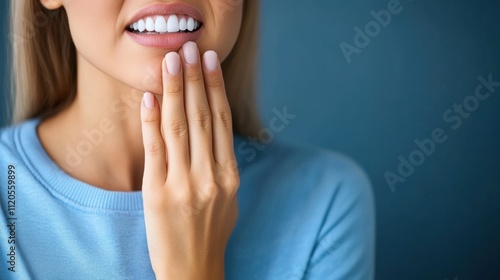 Wallpaper Mural Close-up of a Woman's Hand Touching Her Mouth with a Soft Smile and Natural Makeup on a Blue Background Torontodigital.ca