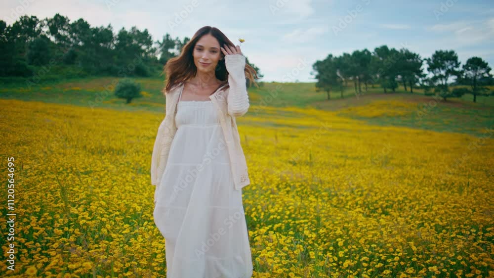 Brunette enjoy walk meadow at summer. Girl strolling at yellow flowers field Brunette enjoy walk meadow at summer. Girl strolling at yellow flowers field