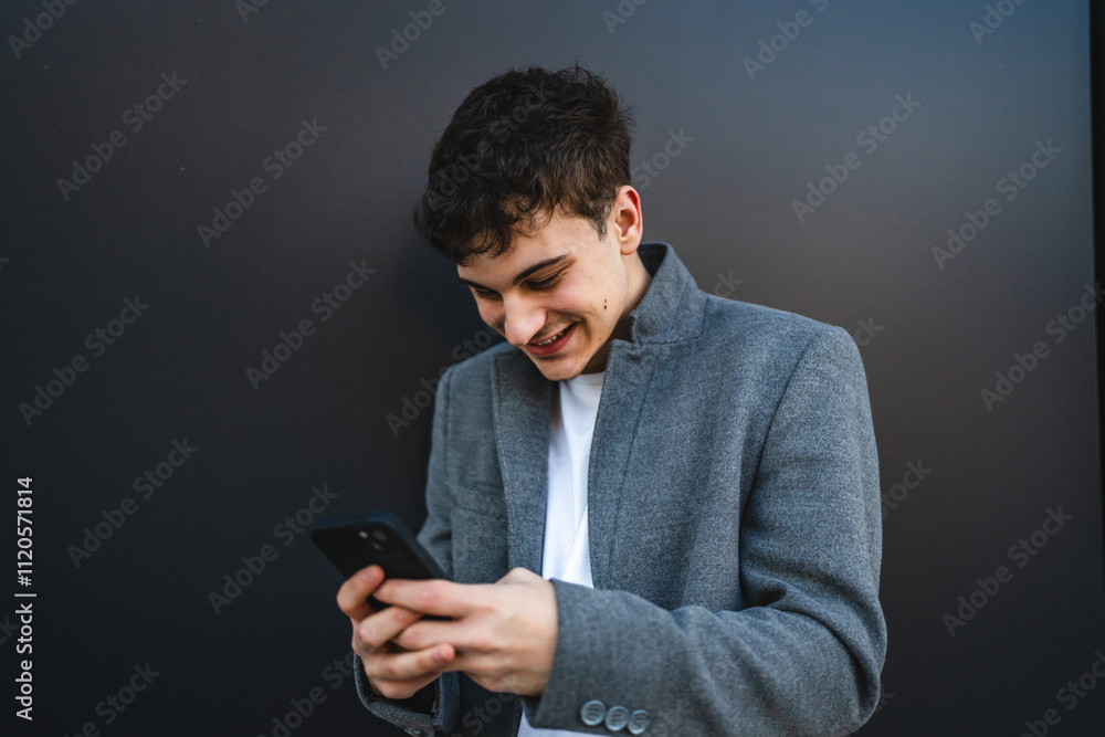 young cheerful man use mobile phone in front black wall outdoor young cheerful man use mobile phone in front black wall outdoor