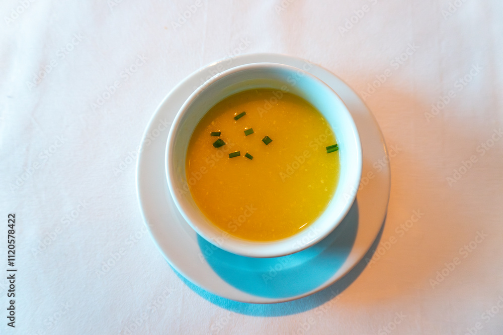 cup of yellow corn soup on a cloth table cup of yellow corn soup on a cloth table
