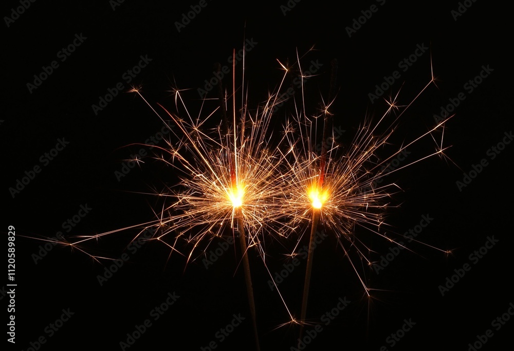 Burning sparklers glowing in dark, space for text Burning sparklers glowing in dark, space for text