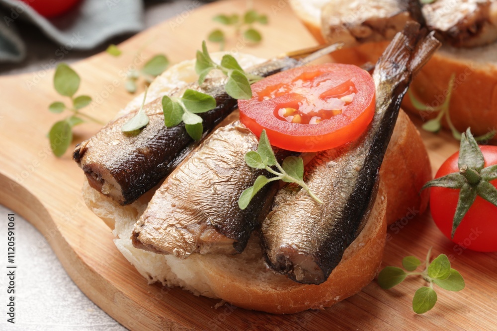 Delicious sandwich with sprats, microgreens and tomatoes on table, closeup
