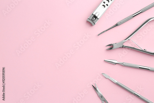 Set of pedicure tools on pink background, flat lay. Space for text photo