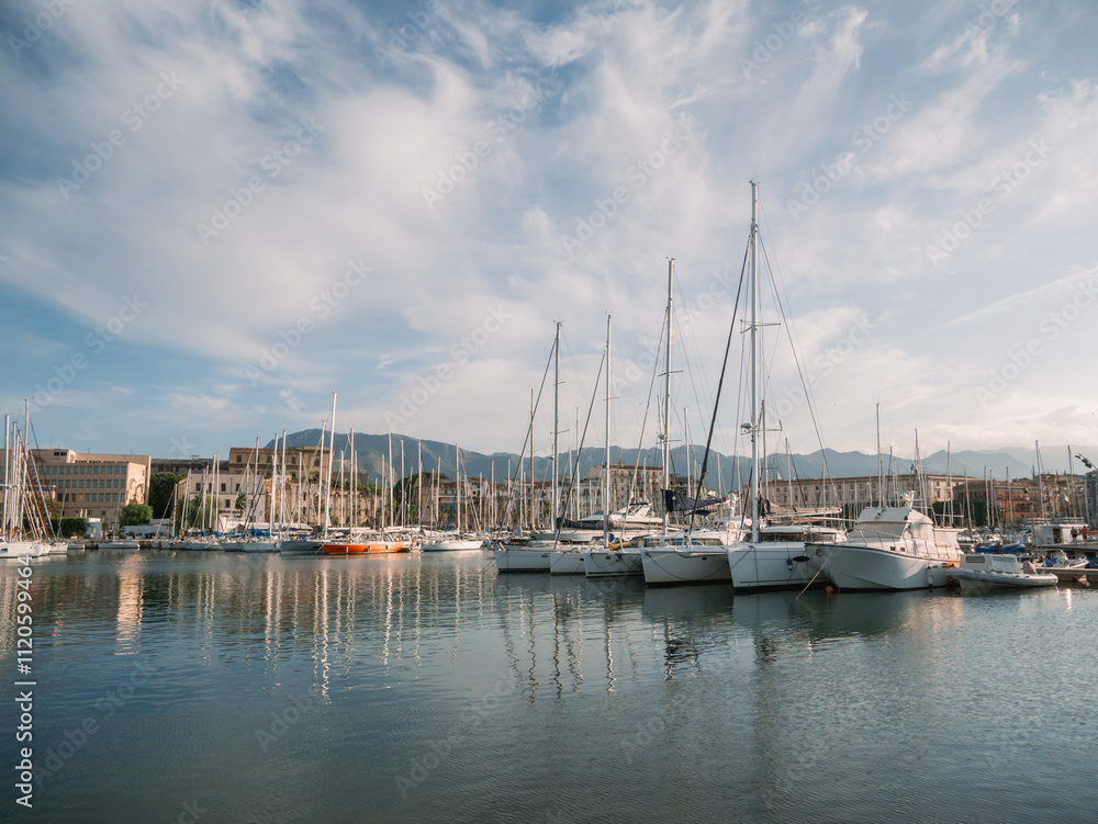 Naklejka premium Sailboats and motorboats docked at Palermo marina with historic buildings