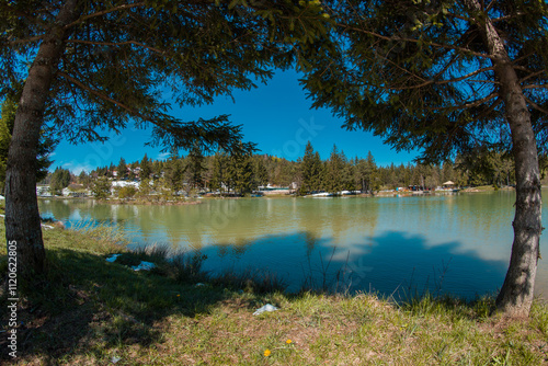 Beautiful blosko jezero or bloke lake in early spring, with cold lake, green grass and snow patches still visible... photo