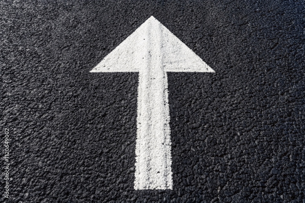 An aerial shot captures a white arrow road sign on dark asphalt, representing direction and forward movement in city landscapes for enhanced navigation. An aerial shot captures a white arrow road sign on dark asphalt, representing direction and forward movement in city landscapes for enhanced navigation.