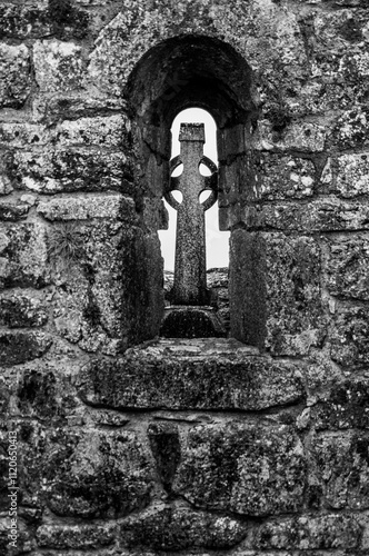 A stone wall with a cross on it photo