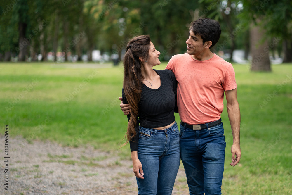 Young couple in love walking arm in arm in the park Young couple in love walking arm in arm in the park