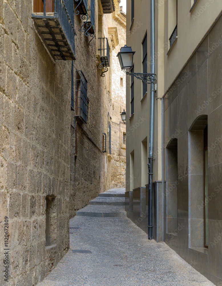 Small narrow alley between stone buildings in the city of Granada, Spain Small narrow alley between stone buildings in the city of Granada, Spain