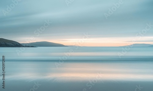 Serene seascape at dawn with soft colors and gentle waves.