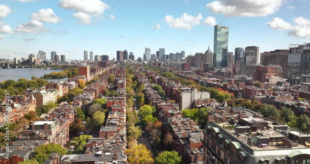 Aerial over brick brownstones and autumn trees with the Boston city skyline
