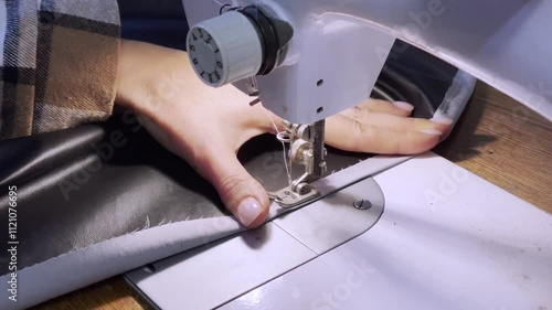 close up of a sewing machine needle in the activity of someone sewing clothes