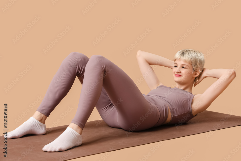 Fototapeta premium Sporty young woman training on beige background