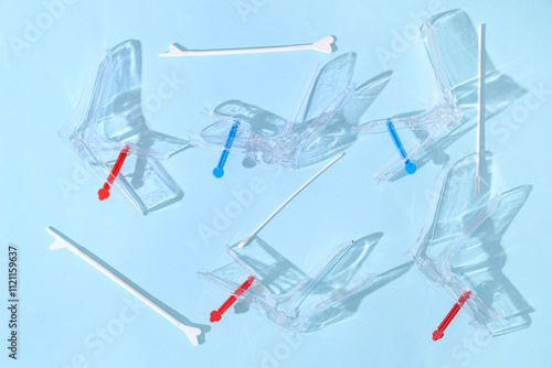 Gynecological speculums with pap smear test tools on light blue background photo