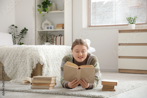 Young woman reading book on...