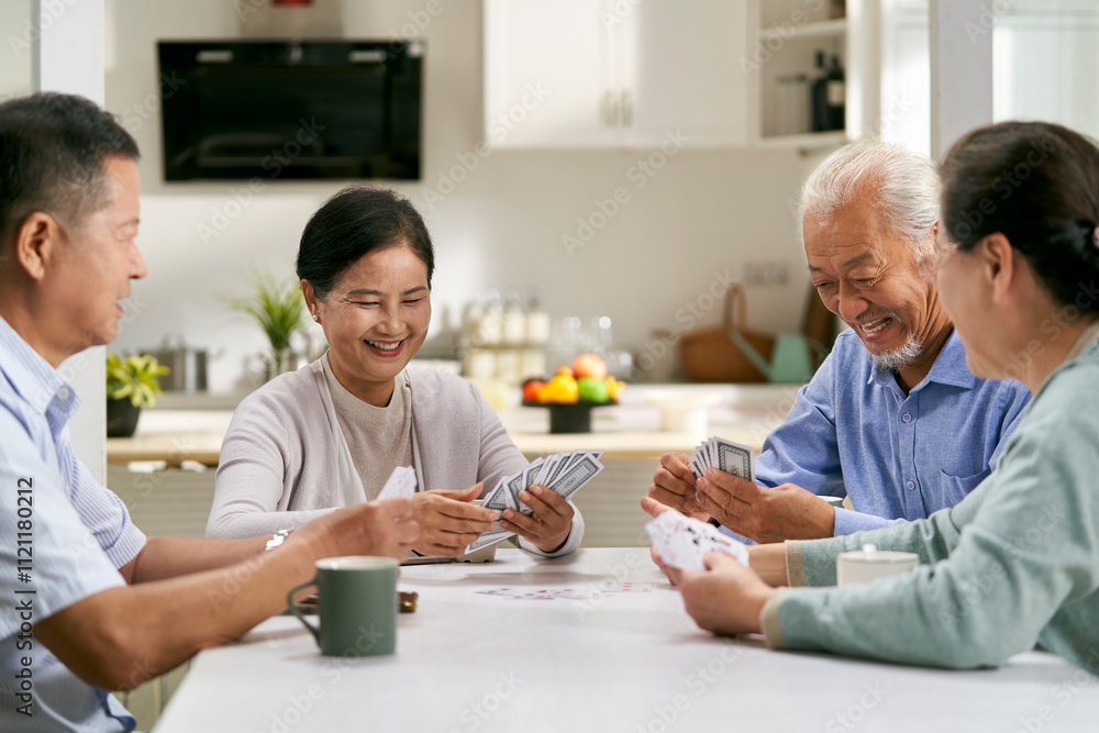 Obraz premium group of happy senior asian people two couples playing cards at home