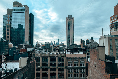 A cloudy New York City skyline featuring iconic rooftop water towers, historic architecture, and modern high-rises, capturing urban contrast #1121180843