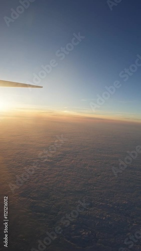 Stunning sunset over the clouds from an airplane window