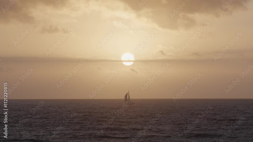 Sailing silhouette at sunset over the calm ocean waters near the coast Sailing silhouette at sunset over the calm ocean waters near the coast