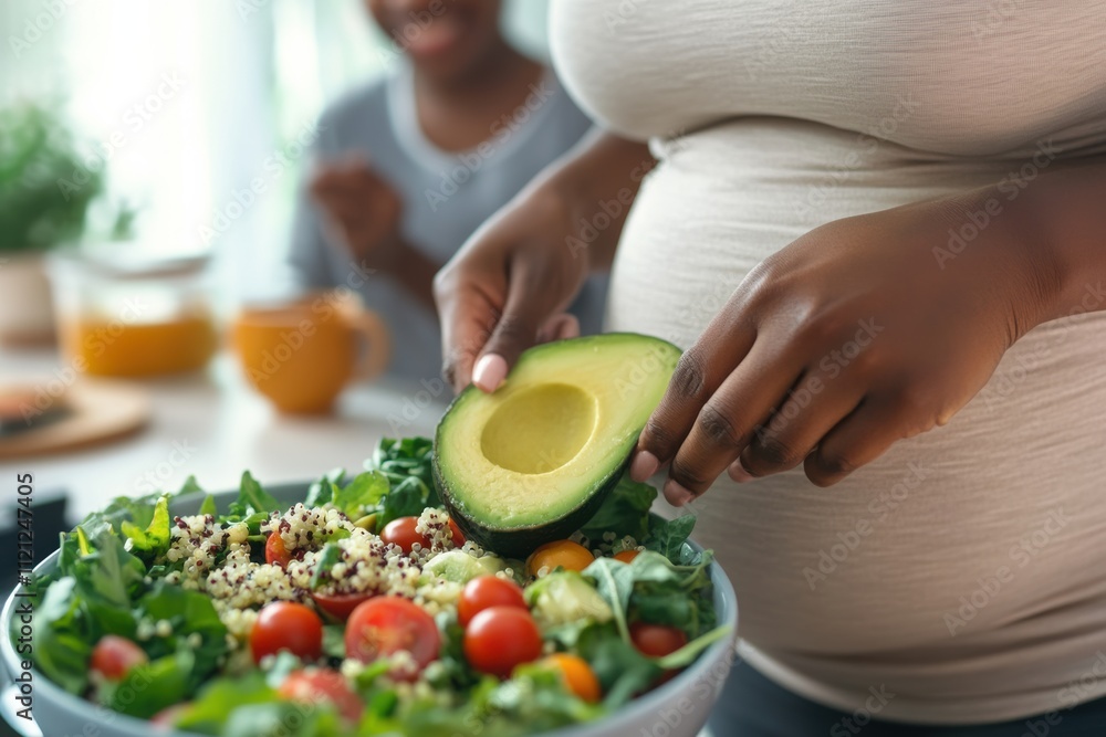 Close-up of a pregnant woman adding avocado to a vibrant salad with quinoa, spinach, and cherry tomatoes, promoting healthy eating and lifestyle. Close-up of a pregnant woman adding avocado to a vibrant salad with quinoa, spinach, and cherry tomatoes, promoting healthy eating and lifestyle.