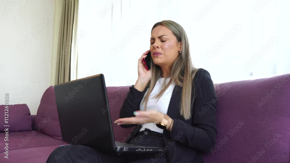 Young Stressful Business Woman Talking Over Smartphone and Typing on Laptop Computer Young Stressful Business Woman Talking Over Smartphone and Typing on Laptop Computer