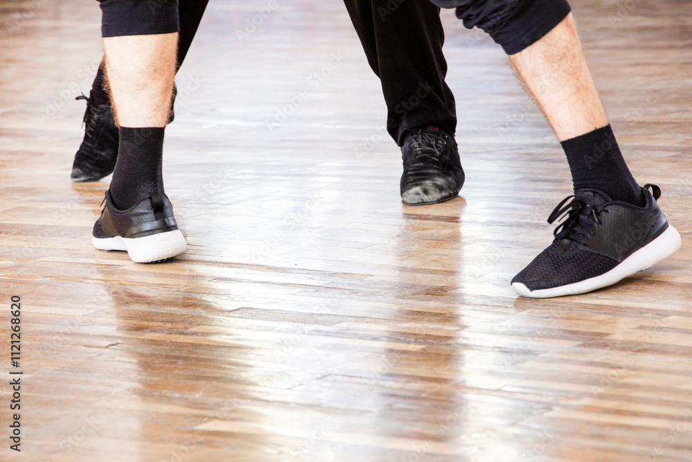 dancer practices in worn out leather shoes on the floor with a teacher dancer practices in worn out leather shoes on the floor with a teacher