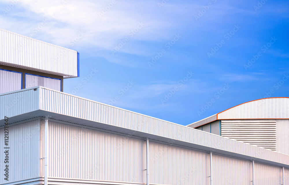 Modern industrial factory buildings group with geometric exterior aluminium wall against blue sky background, Low angle and perspective side view with copy space Modern industrial factory buildings group with geometric exterior aluminium wall against blue sky background, Low angle and perspective side view with copy space