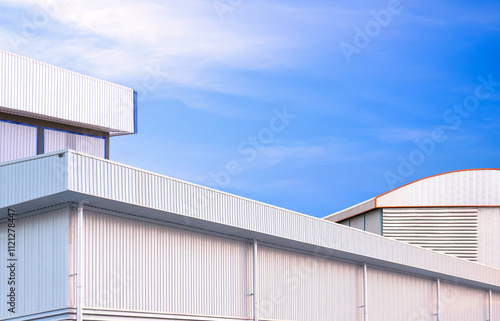 Modern industrial factory buildings group with geometric exterior aluminium wall against blue sky background, Low angle and perspective side view with copy space