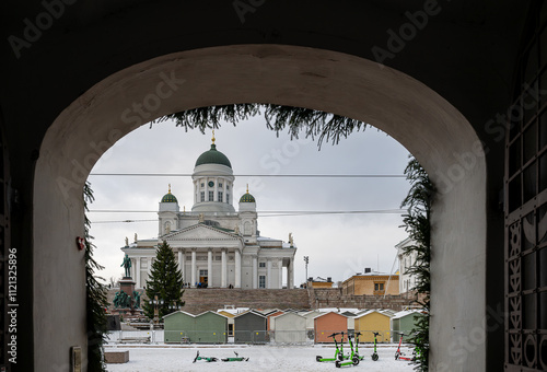 View of cathedral through archway with snowy market scene in Helsinki, Finland photo