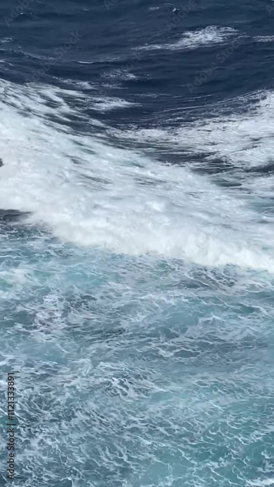 Waves and white seething foam from a cruise ship sailing. Blue turbulent water of the Pacific Ocean. Water of the open ocean on a sunny day. View from a cruise ship. Waves and white seething foam from a cruise ship sailing. Blue turbulent water of the Pacific Ocean. Water of the open ocean on a sunny day. View from a cruise ship.