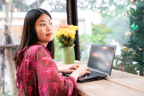 Business asian red suit woman sitting in cafe drink coffee use laptop computer photo