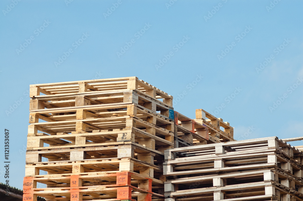 Riga, Latvia – March 14, 2024:pallets stacked against blue sky Riga, Latvia – March 14, 2024:pallets stacked against blue sky