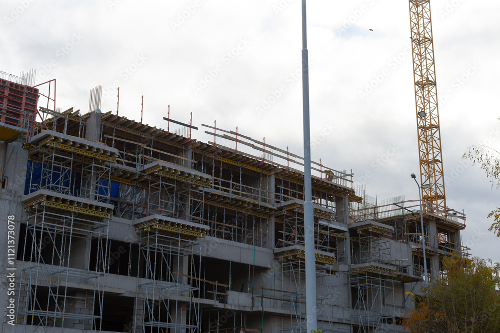 A significant large building is currently under construction, prominently featuring a crane in the background assisting with the work A significant large building is currently under construction, prominently featuring a crane in the background assisting with the work