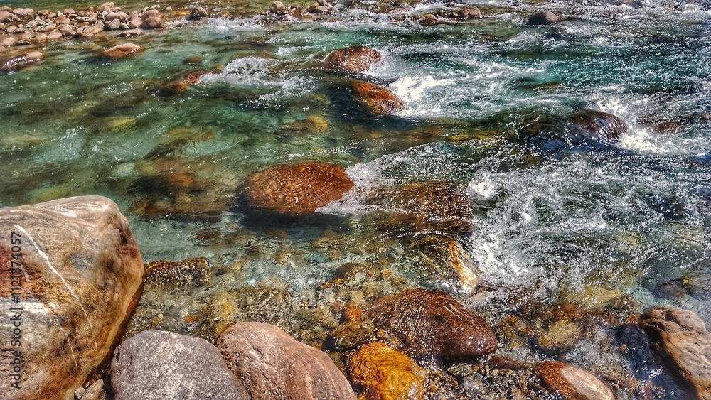 Crystal-Clear River Flowing Over Smooth Stones Crystal-Clear River Flowing Over Smooth Stones