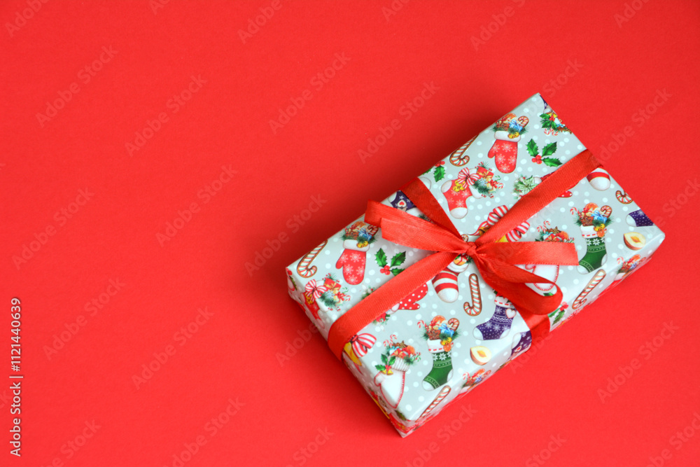 a gift with a red ribbon tied around it isolated on red background top view a gift with a red ribbon tied around it isolated on red background top view