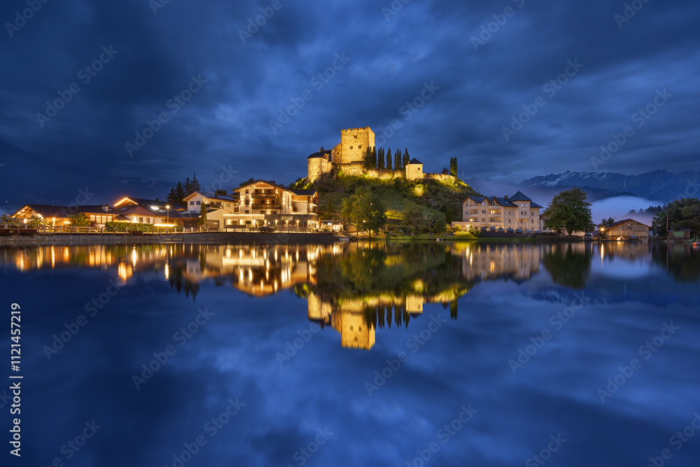 Burg in Österreich zur blauen Stunde mit Spiegelung in einem See bei bewölktem Himmel Burg in Österreich zur blauen Stunde mit Spiegelung in einem See bei bewölktem Himmel