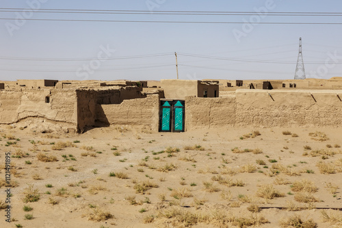 Traditional adobe house with vibrant blue doors in Sheberghan, Jowzjan Province, Afghanistan photo