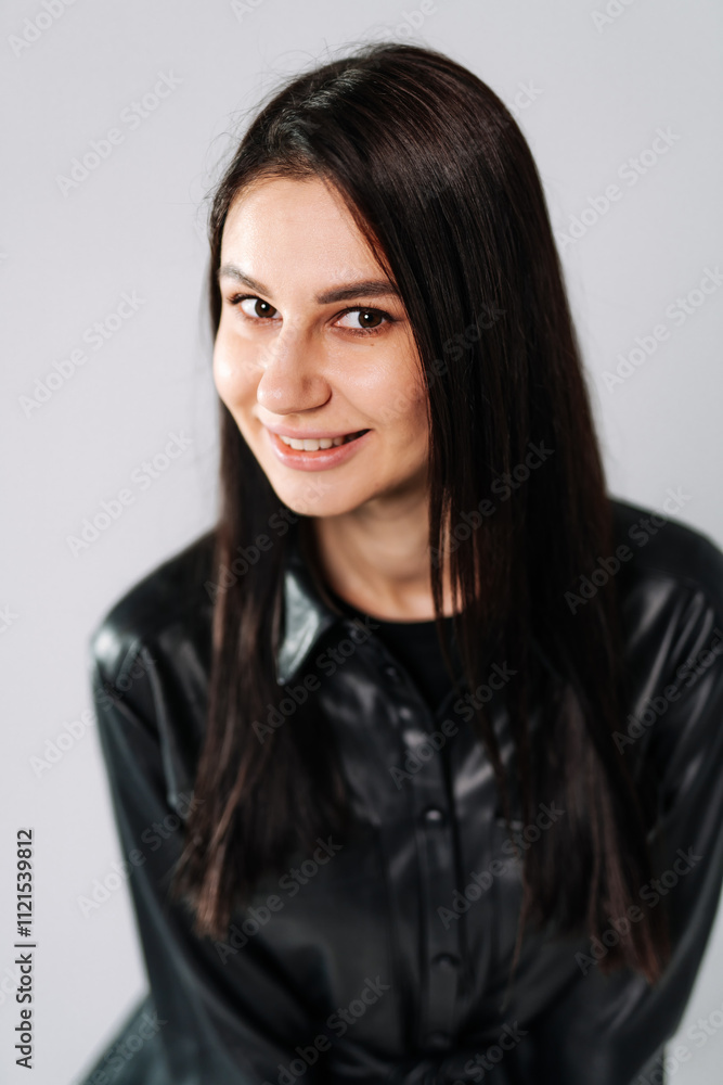 Young woman with long hair in stylish outfit. A young woman smiles gently while wearing a fitted black shirt. Her long hair frames her face attractively. Young woman with long hair in stylish outfit. A young woman smiles gently while wearing a fitted black shirt. Her long hair frames her face attractively.