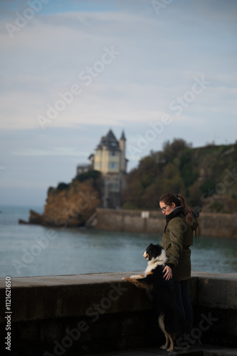 woman watching the sunset with her dog in Biarritz