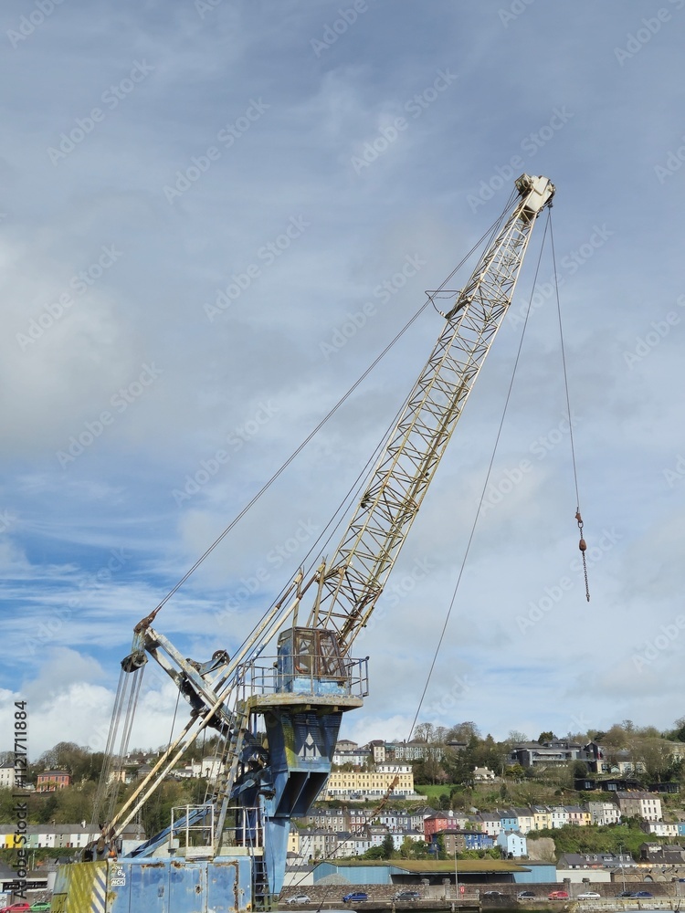 Construction Crane Near Water with Vehicles and Cloudy Sky Construction Crane Near Water with Vehicles and Cloudy Sky