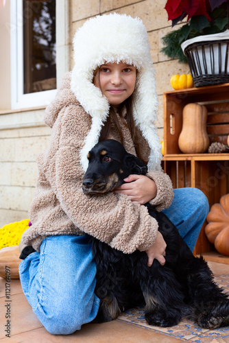 Portrait of a girl with a black spaniel.