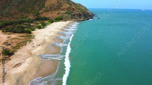 beautiful beach with a blue ocean and a mountain in the background