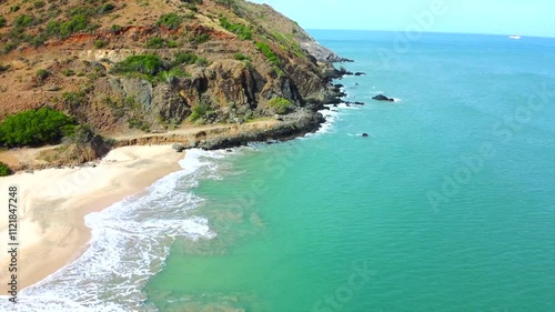 beautiful beach with a blue ocean and a mountain in the background