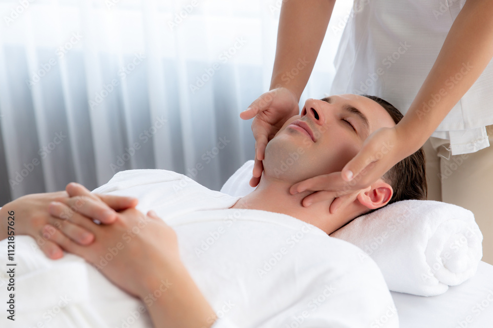 Caucasian man enjoying relaxing anti-stress head massage and pampering facial beauty skin recreation leisure in dayspa modern light ambient at luxury resort or hotel spa salon. Quiescent Caucasian man enjoying relaxing anti-stress head massage and pampering facial beauty skin recreation leisure in dayspa modern light ambient at luxury resort or hotel spa salon. Quiescent