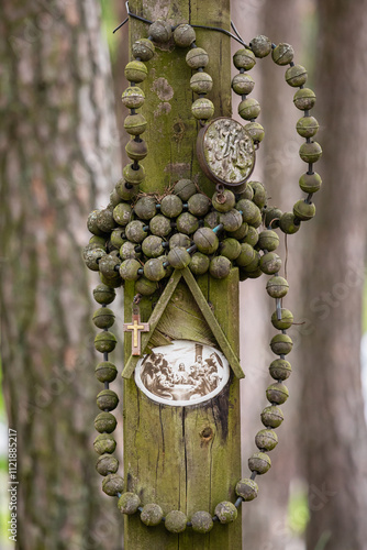 Antique wooden pillar with rosary, cross and image of the Last Supper